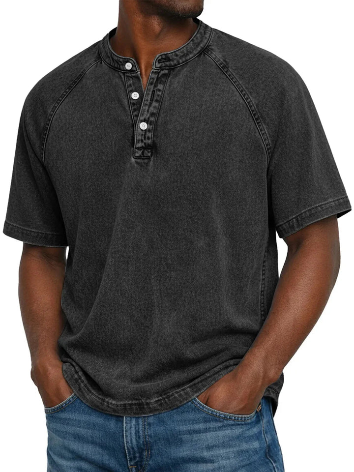 Man draagt het gewassen Henley-shirt met korte raglanmouwen in zwart, met een verwassen uitstraling en knoopsluiting. 5