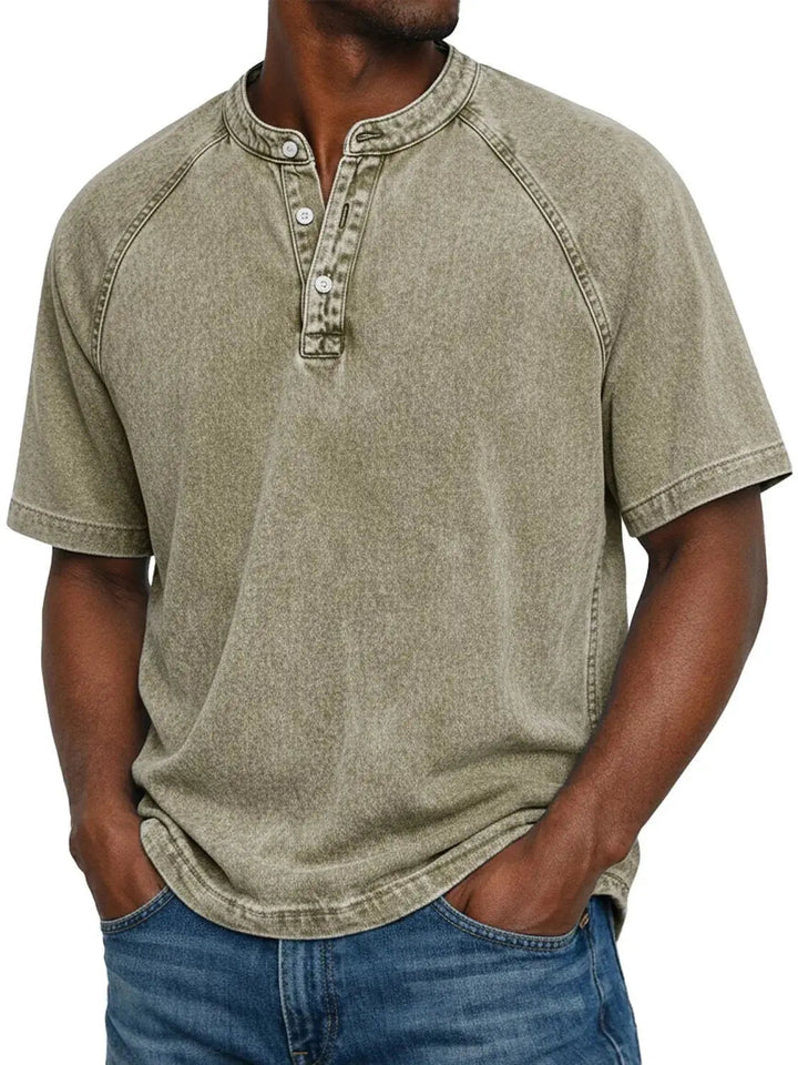 Man draagt het gewassen Henley-shirt met korte raglanmouwen in kaki of zandkleur, met een verwassen look. 9