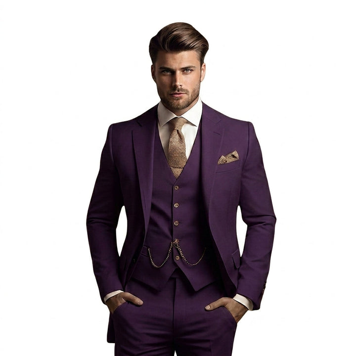 Model draagt het kostuum in donkerpaars met wit overhemd, beige gebreide das, pochet en horlogeketting aan het gilet, handen in de zakken. 6