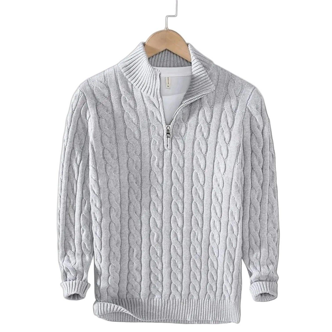Lichtgrijze kabeltrui met opstaande kraag en korte rits aan een houten kleerhanger, met een wit shirt eronder. 4