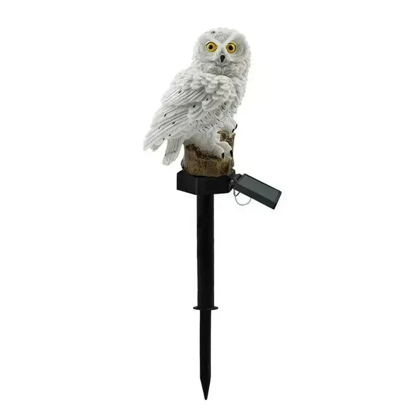 Witte uilenlamp op zwarte prikstok met klapbaar zonnepaneel, vrijstaand op een witte achtergrond. 15