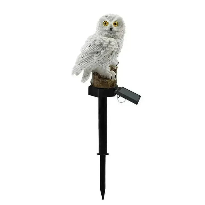 Witte uilenlamp op zwarte prikstok met klapbaar zonnepaneel, vrijstaand op een witte achtergrond. 15