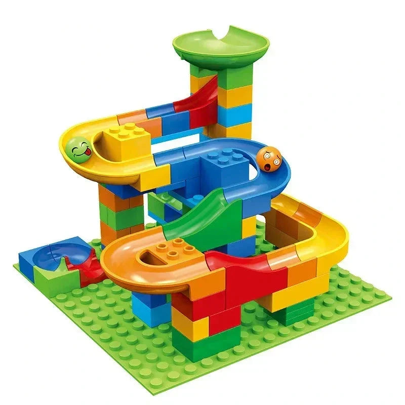 Kleine knikkerbaan met een groene trechter bovenin en bochtige banen in geel, blauw en oranje op een groene noppenplaat. 3