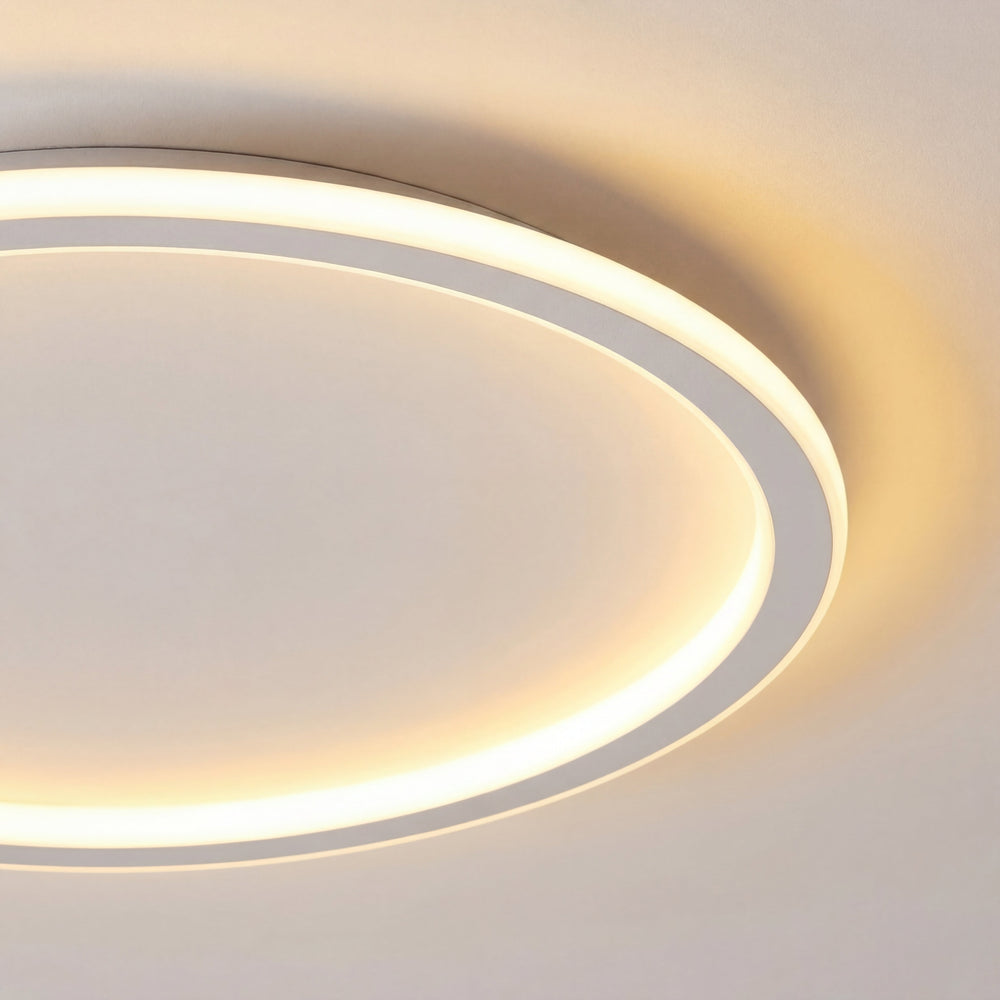 Close-up van een deel van de ringvormige plafondlamp met zachte, warme verlichting en de witte rand. 2