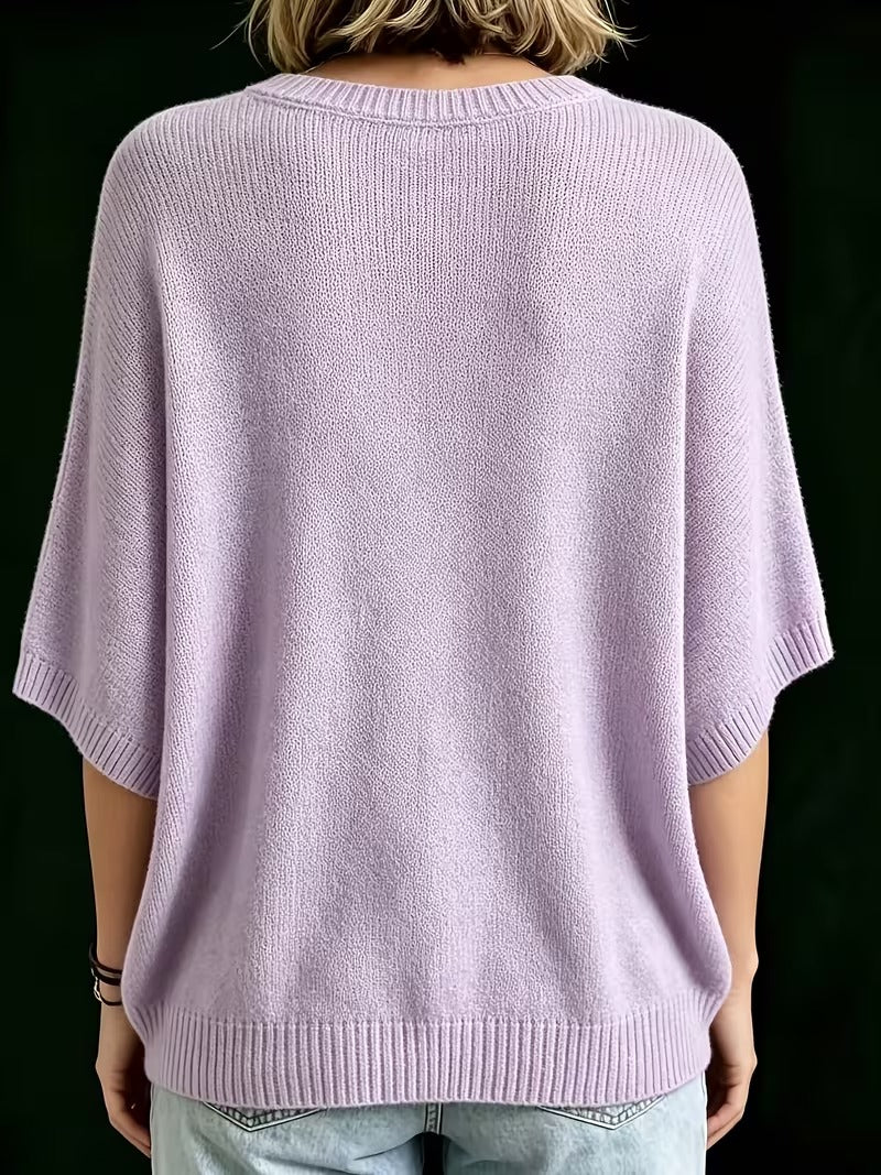 Achterkant van de lila gebreide top met ronde hals, korte wijde mouwen en geribbelde zoom, gedragen met jeans. 9
