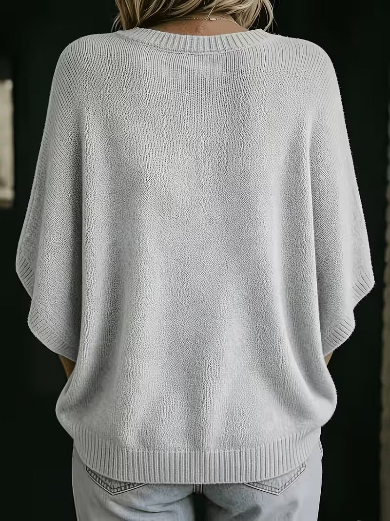 Achterkant van de lichtgrijze gebreide top met ronde hals, ruime vleermuismouwen en geribbelde zoom, gedragen met jeans. 3