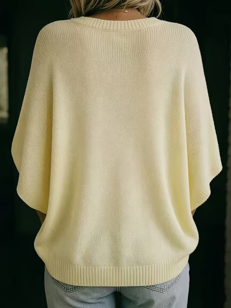 Achterkant van de lichtgele gebreide top met ronde hals en wijde vleermuismouwen, gedragen met lichte jeans. 6