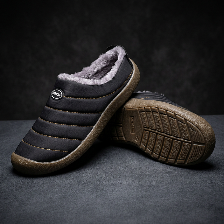 Zwarte pantoffel met pluche voering, naast de ander met zichtbaar antislip profiel onder de zool 19