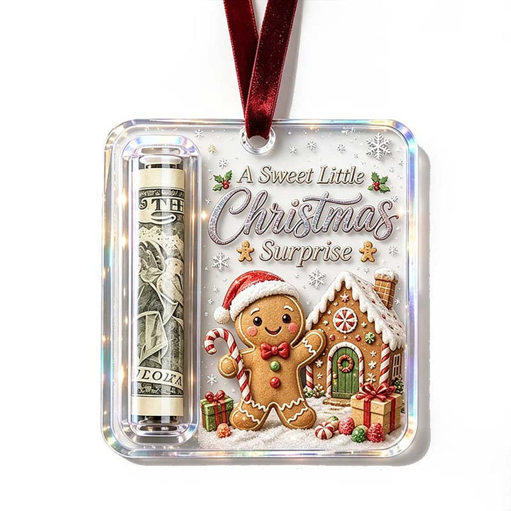 Hanger op witte achtergrond met een peperkoekmannetje met kerstmuts bij een peperkoekhuisje, naast het opgerolde biljet. 20