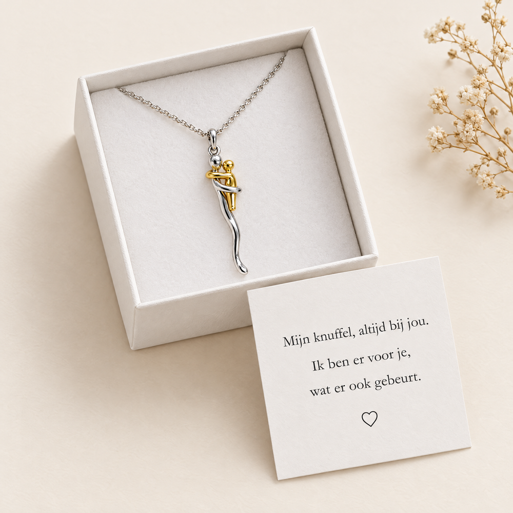 De ketting ligt in een open wit cadeaudoosje met een kaartje met een gedichtje en hartje ernaast, naast een takje droogbloemen. 2