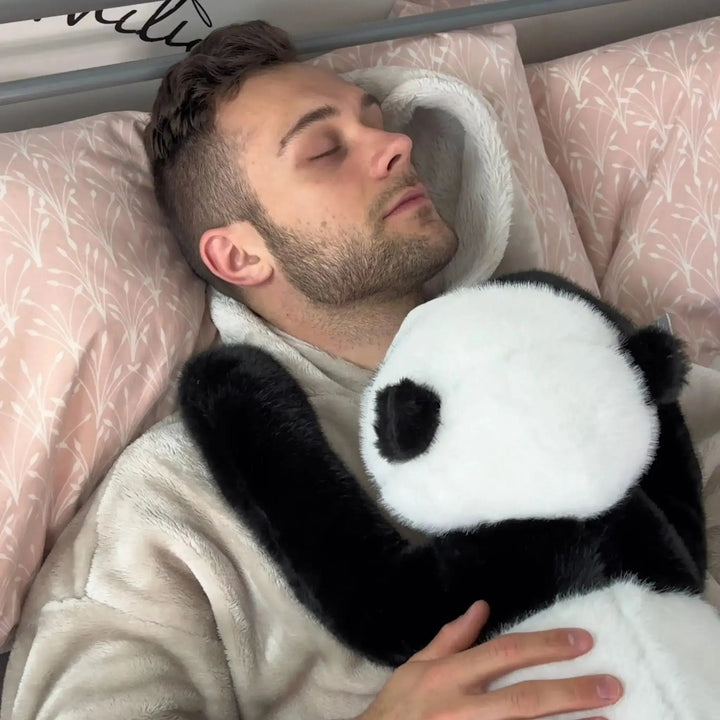 Slapende man in bed met de panda-knuffel in zijn armen, met zijn zwarte arm om zijn schouder. 11