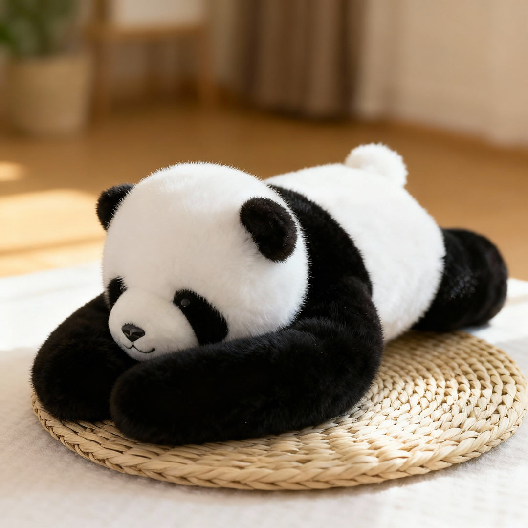 Zwart-witte panda-knuffel met lange armen ligt op een rieten onderzetter, met een zacht pluizige vacht in een zonnige kamer. 1