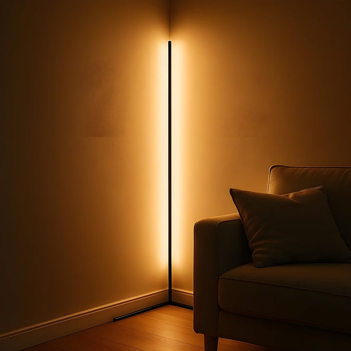 Dunne lamp in de hoek van een schemerige kamer werpt een warm gouden gloed over beide muren naast een bank. 3