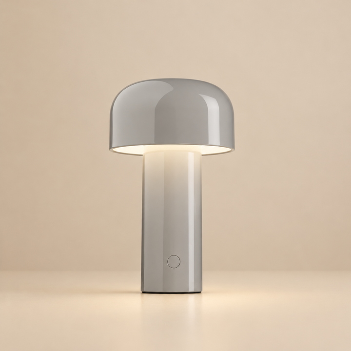 Lichtgrijze glanzende tafellamp met warm licht onder de kap en een knopje op de voet 32