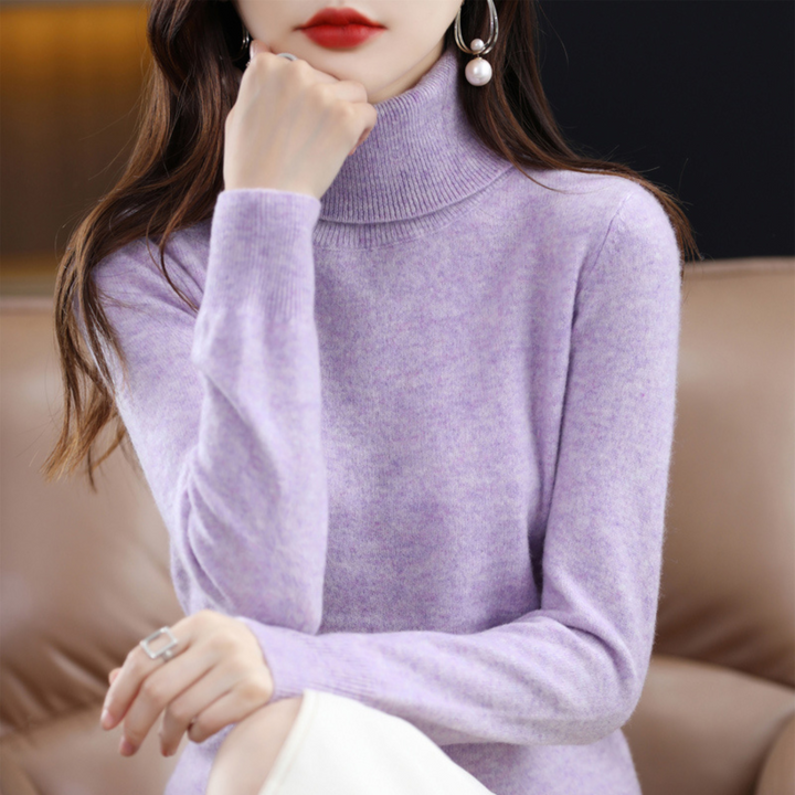Lila gemêleerde coltrui gedragen door een model dat haar hand bij haar kin houdt, voor een bruine bank. 6