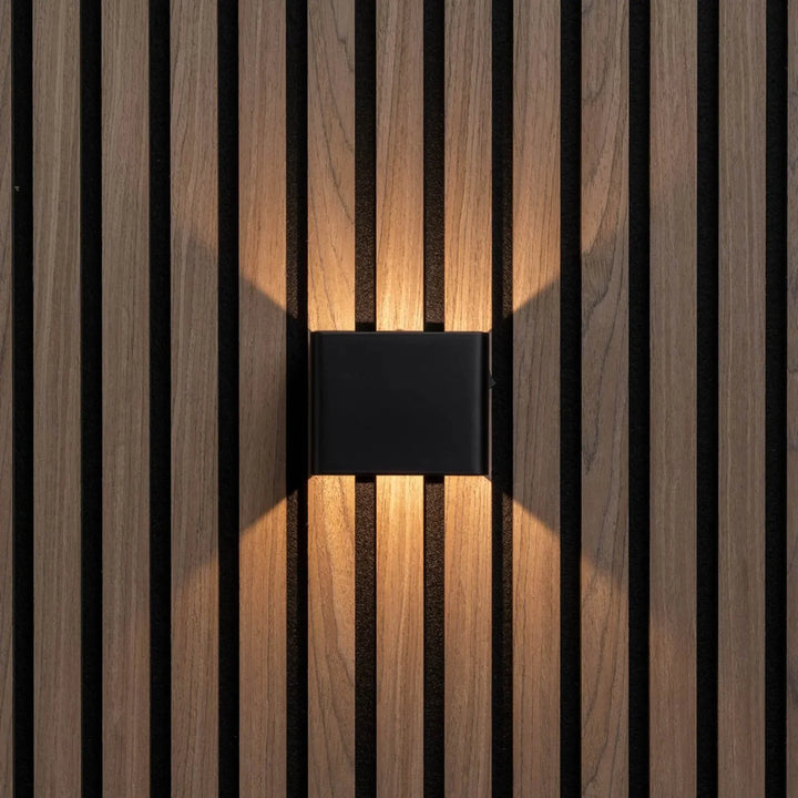 Zwarte wandlamp recht van voren op houten lamellenwand, met warm licht omhoog en omlaag 5