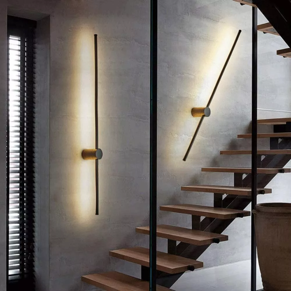 Twee zwarte lichtstaven op een grijze betonnen muur naast een houten trap, één verticaal en één schuin gedraaid. 4
