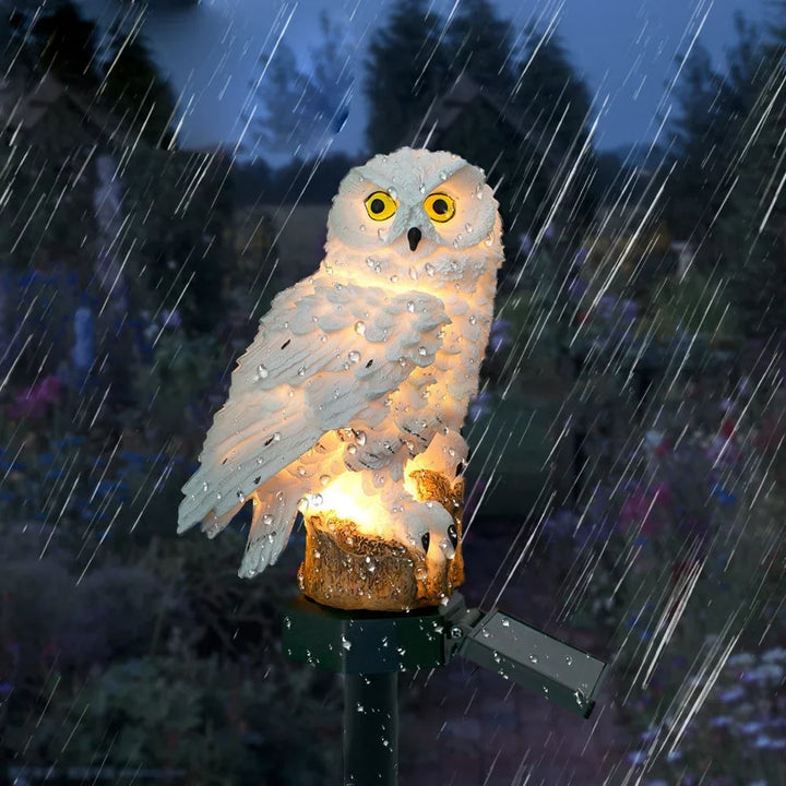 Verlichte witte uilenlamp in de stromende regen, met waterdruppels op het beeld, om de waterbestendigheid te tonen. 10