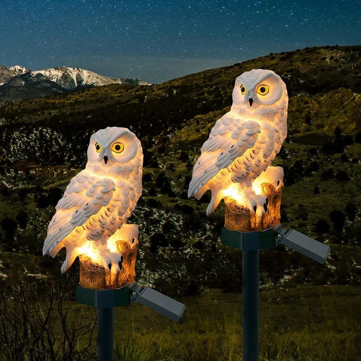 Twee verlichte witte uilenlampen met zonnepaneel in een heuvelachtig landschap onder een sterrenhemel. 4