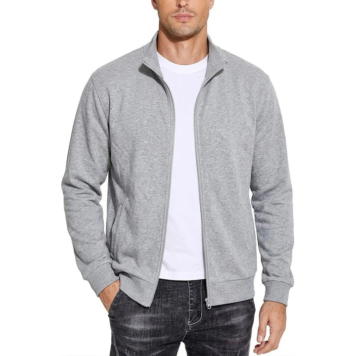 Model draagt de sweatjack in gemêleerd lichtgrijs, open ritssluiting over een wit T-shirt, een hand in de zak. 7