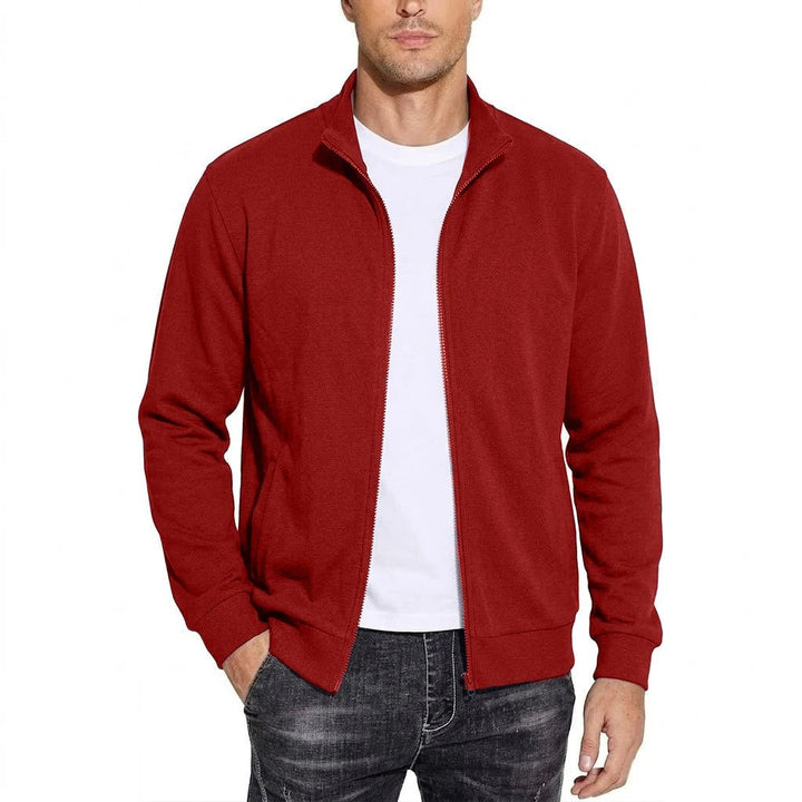 Model draagt de sweatjack in rood, open ritssluiting over een wit T-shirt, een hand in de zak. 4