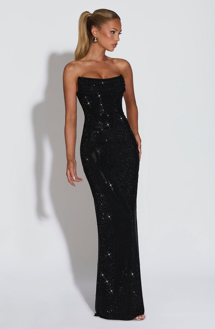 Driekwart zijaanzicht van de zwarte strapless maxi-jurk met strass, model met hoge paardenstaart en strak aansluitende pasvorm. 25