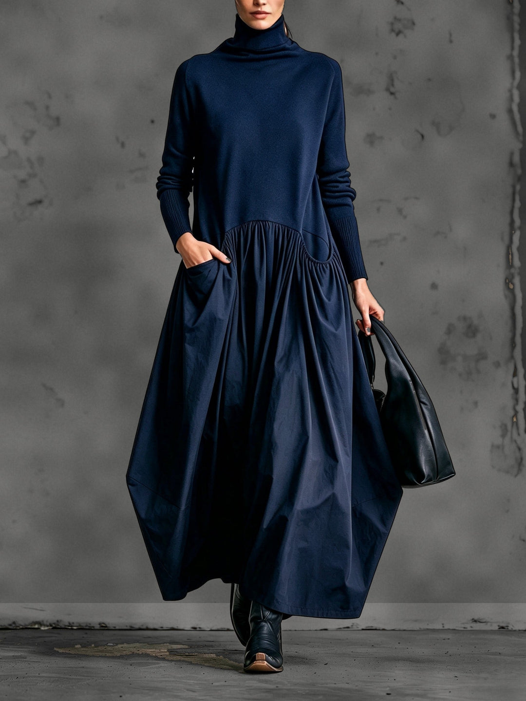 Model in marineblauwe maxi-jurk met nepcol, gerimpelde rok en zak, met zwarte tas 6