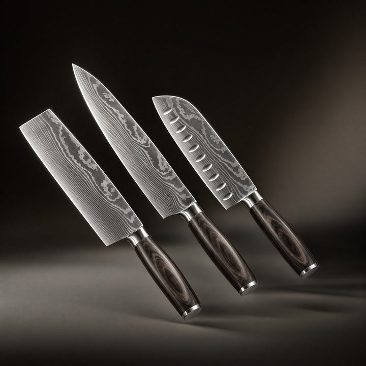Drie messen met golvend gelaagd staalpatroon en donkere houten heften zweven schuin voor een donkere achtergrond, een nakiri, koksmes en santoku. 1