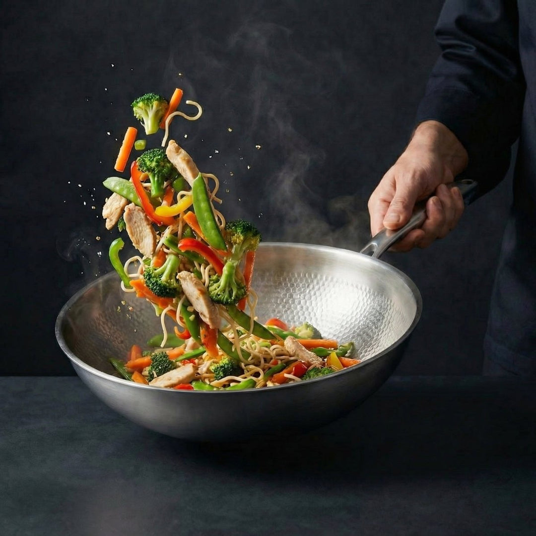 Kok slingert noedels, kip en groenten door de lucht in de wok, die hij bij de steel vasthoudt. 9