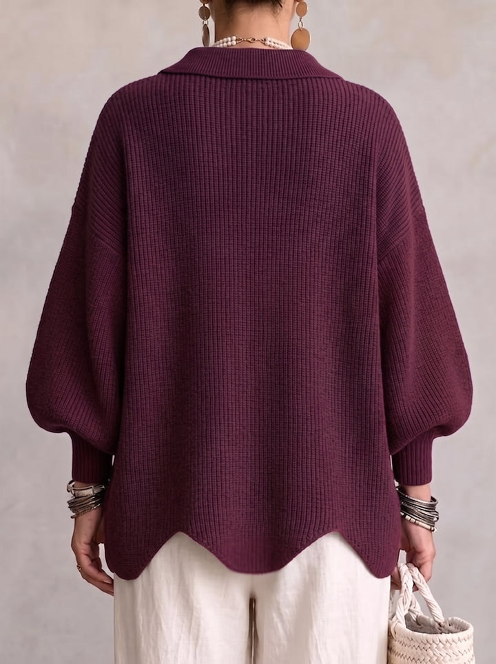 Achterkant van het aubergine vest met brede ribkraag, ballonmouwen met boorden en golvende zoom, gedragen met witte broek. 15