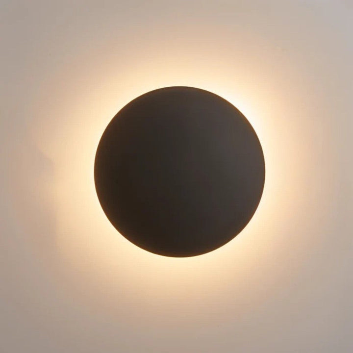 Close-up van de zwarte uitvoering: donkere ronde schijf met warmwit licht langs de rand 2