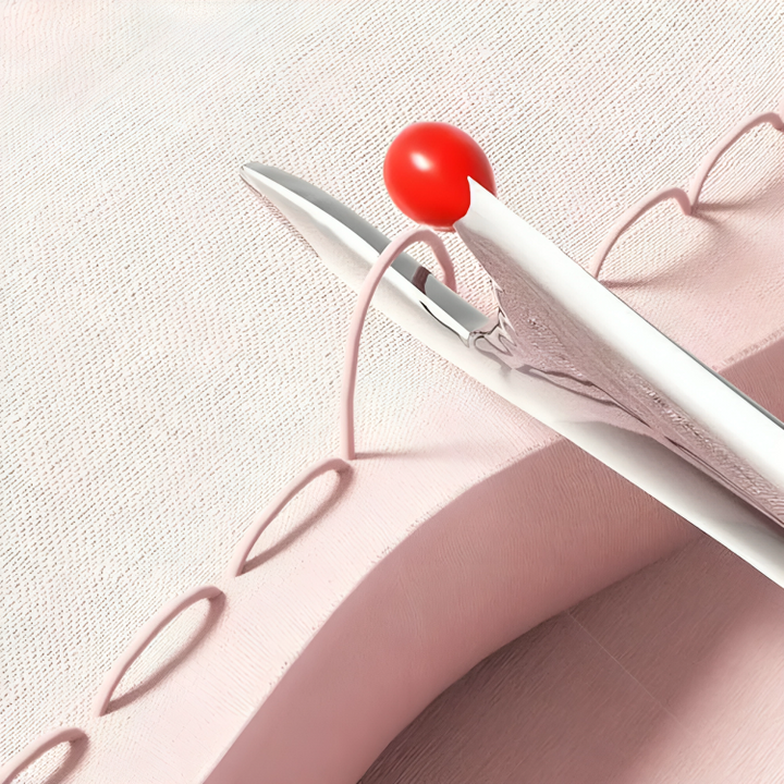 Tornmesje met rood bolletje haalt steken los uit roze stof, vanuit de nabijheid gezien 4
