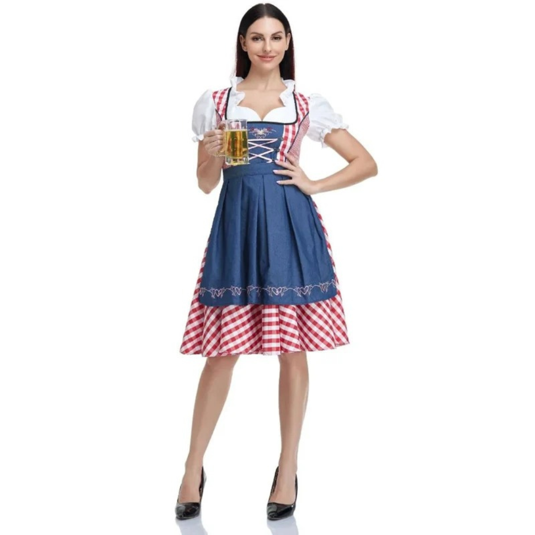 Model in de dirndl met blauwe schort en rood-wit geruite rok houdt een glas bier vast, volledig van voren. 7