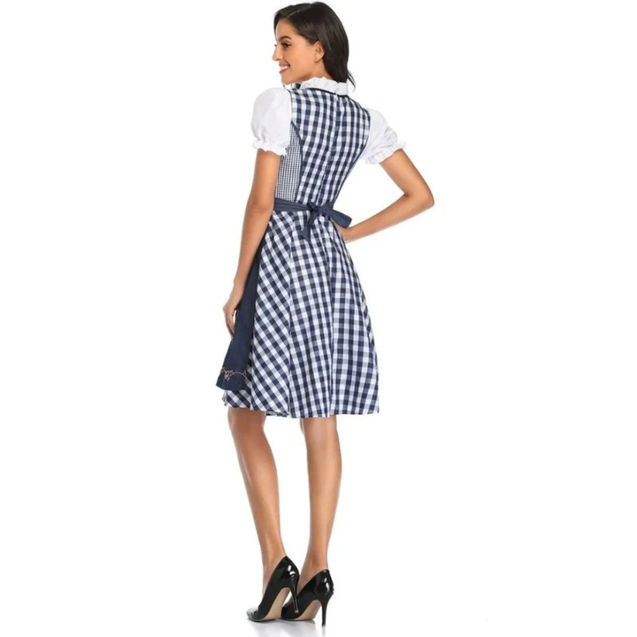 Achterkant van de blauw-wit geruite dirndl met donkerblauwe schortstrik en pofmouwen, model kijkt zijwaarts. 11