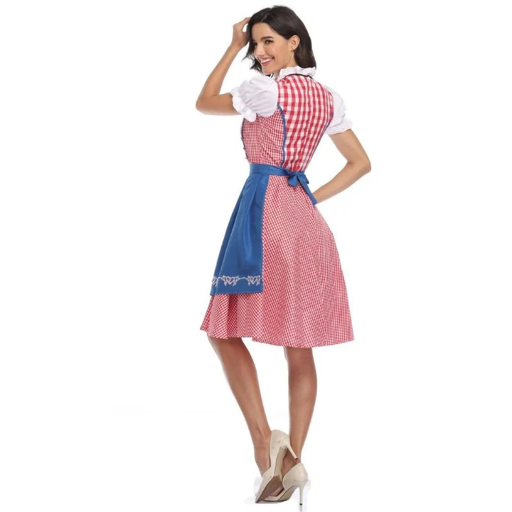 Achterkant van de dirndl met blauwe schortstrik en fijn rood geruite rok, model kijkt lachend over haar schouder. 9
