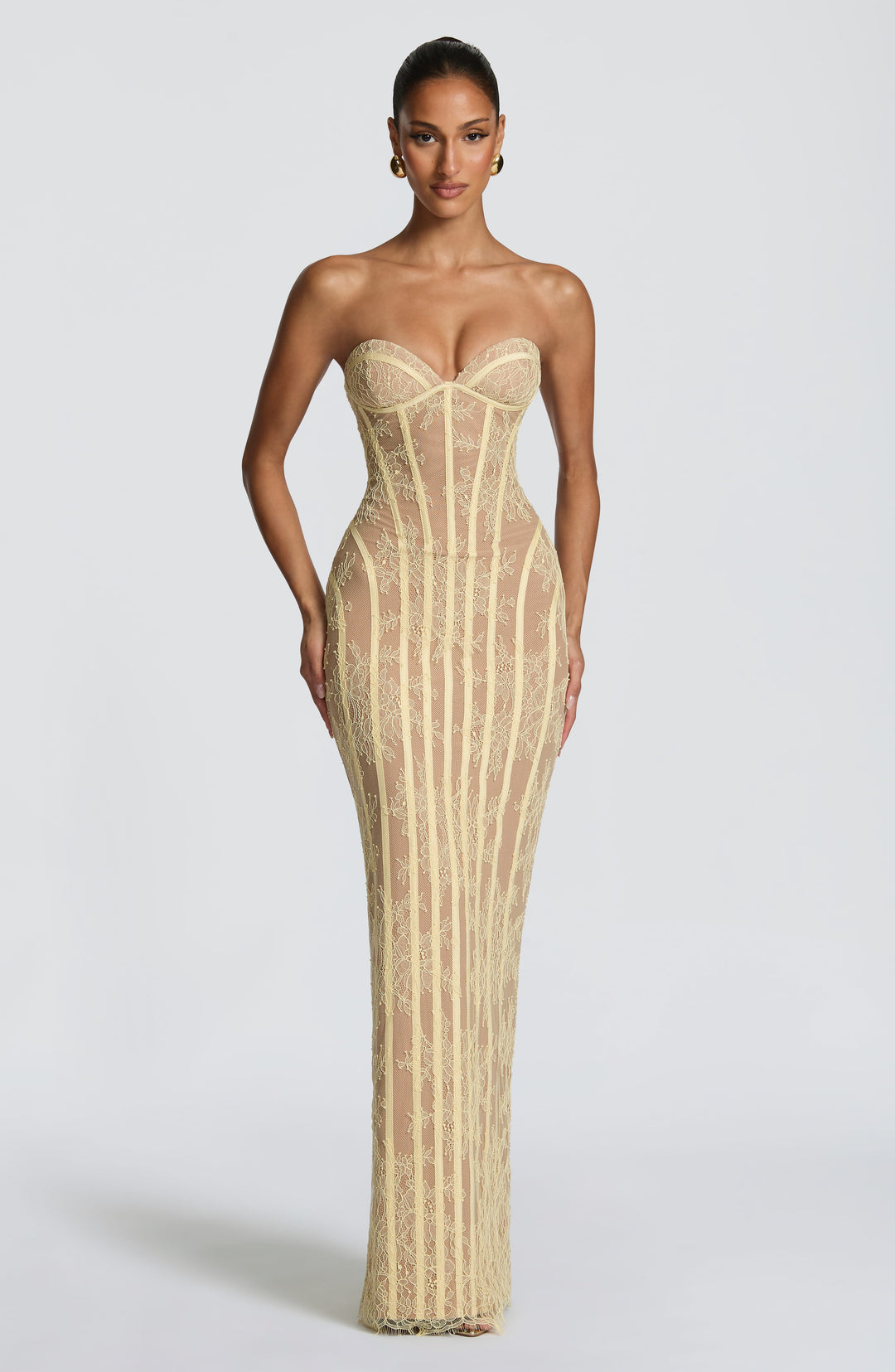 Vooraanzicht van de strapless maxi-jurk van lichtgele kant met korsetbanen over een huidskleurige voering. 17