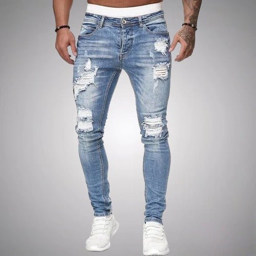 Voorkant van lichtblauwe slim fit jeans met versleten scheuren op dijen en knieën, gedragen met witte sneakers. 2