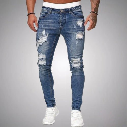 Voorkant van middenblauwe slim fit jeans met gescheurde plekken op de dijen en knieën, gedragen door een model. 3