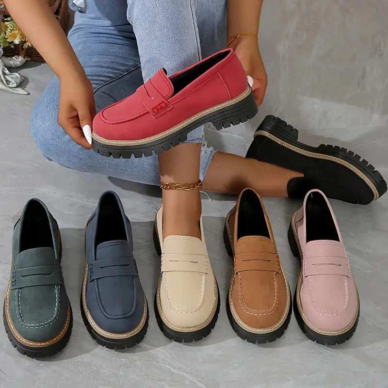 Overzicht van de loafers in groen, blauw, beige, bruin, roze, rood en zwart, waarbij een model de rode schoen omhooghoudt. 2