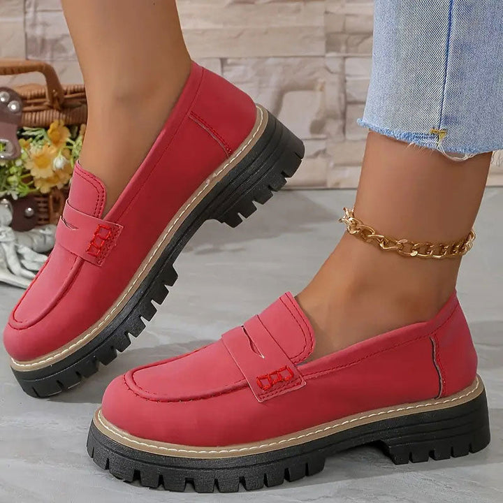 Rode loafers met rode stiksels op de bandjes en zwarte plateauzool, gedragen met gouden enkelbandje. 13