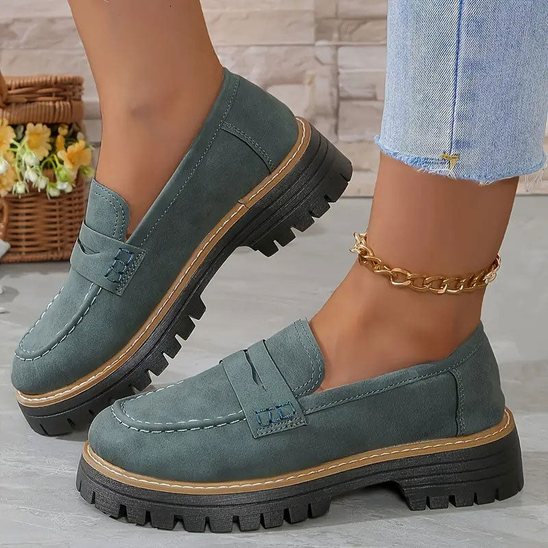 Blauwgroene loafers met contraststiksels en zwarte profielzool, gedragen met gouden enkelbandje en uitgerafelde spijkerbroek. 15