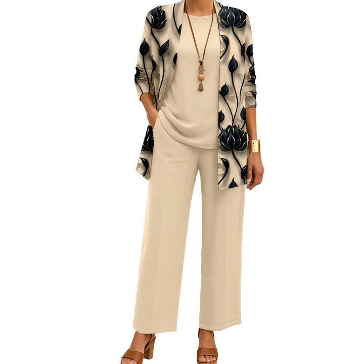 Model draagt de set in beige met een cardigan met zwarte lotusbloemprint, effen top en wijde broek, gecombineerd met een lange ketting. 1