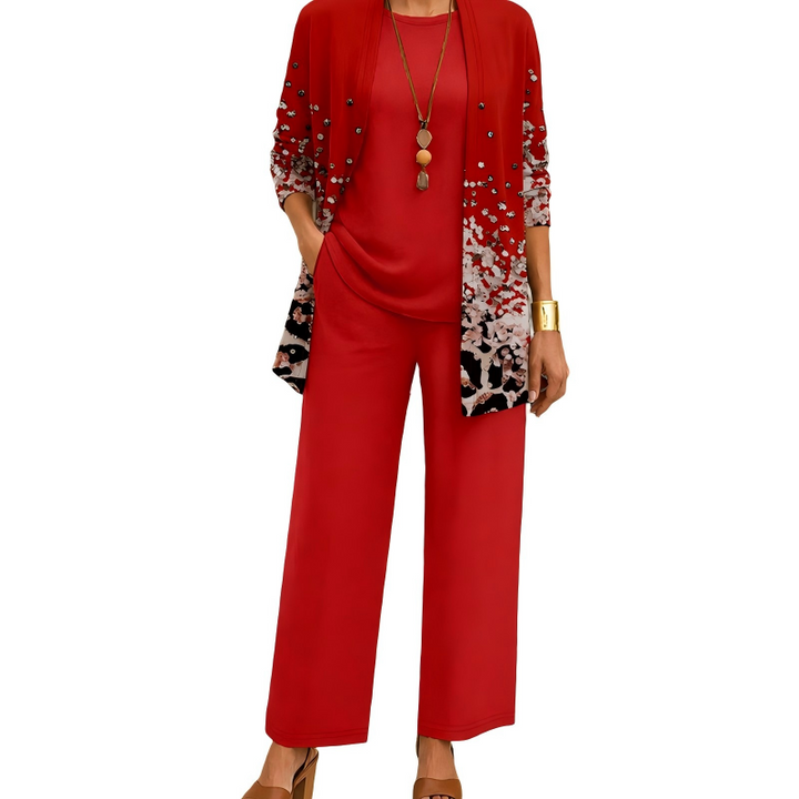 Model draagt de set in rood met een cardigan met verloopprint van lichte stippen en zwarte vlekken, effen top en wijde broek. 5