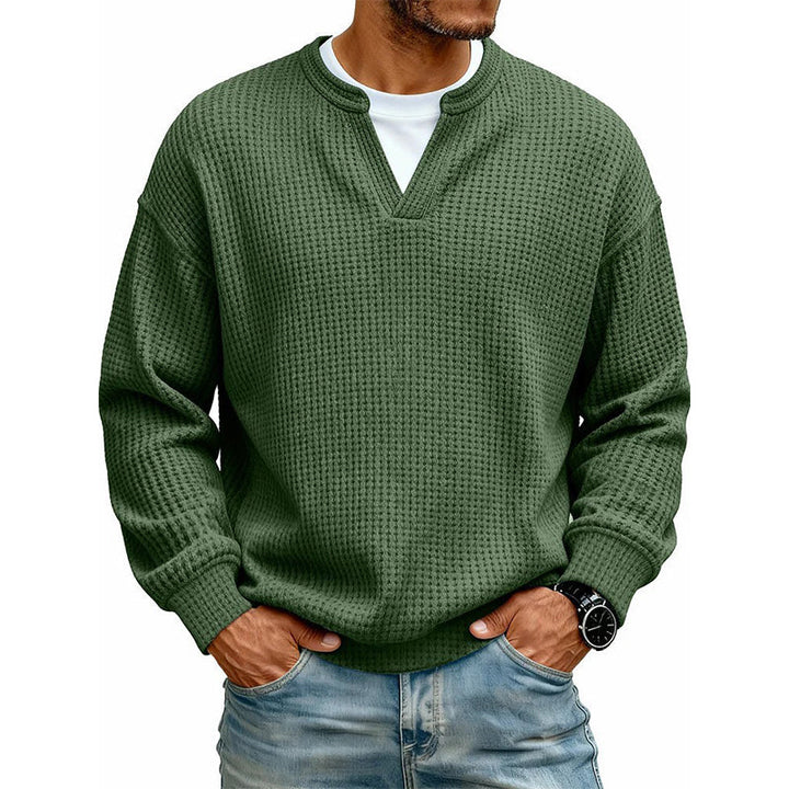 Voorkant van de wafeltop in donkergroen met V-hals en wit shirt eronder, gedragen met jeans. 18