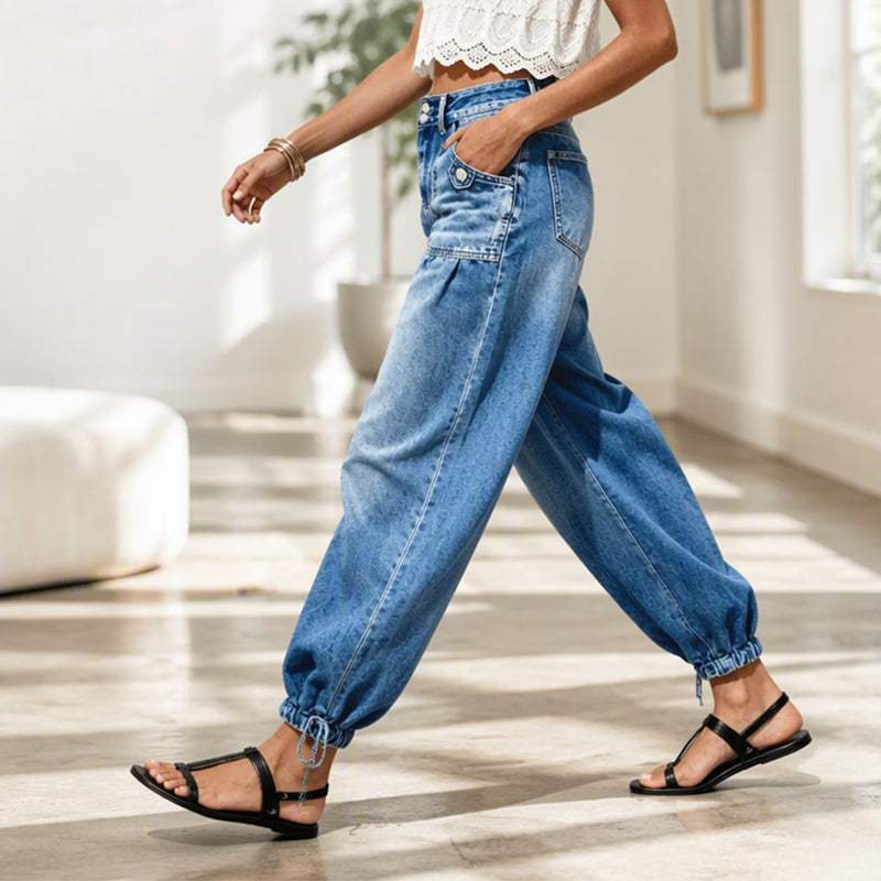 Zijaanzicht van een lopend model in de blauwe jeans met hand in de zak en gestrikte zoom in een lichte ruimte. 7