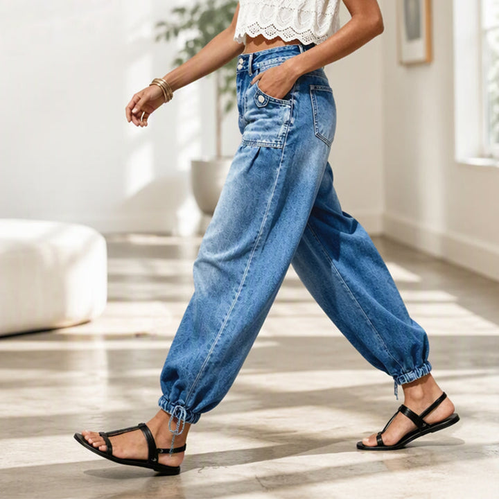 Zijaanzicht van een lopend model in de blauwe jeans met hand in de zak en gestrikte zoom in een lichte ruimte. 7