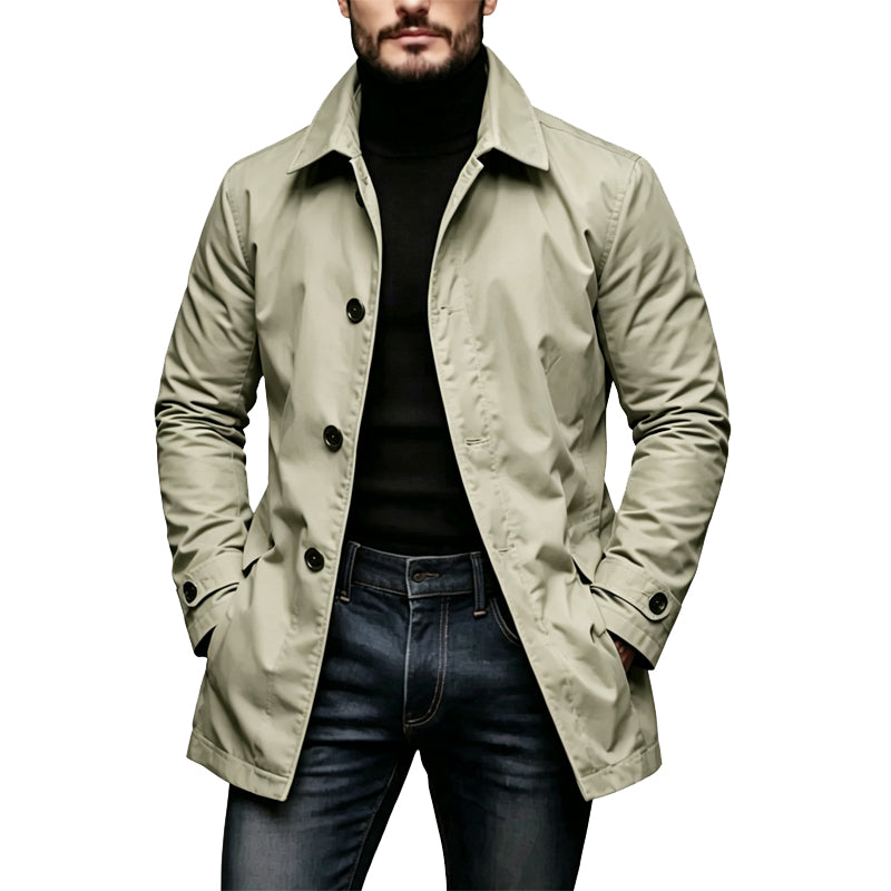 Model draagt de lichte beige versie met knoopsluiting, een zwarte coltrui en spijkerbroek, met de handen in de zakken. 3