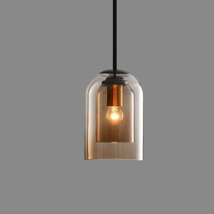 Amberkleurige hanglamp met dubbele glazen kap en brandende gloeilamp, vrijstaand op effen grijze achtergrond 10