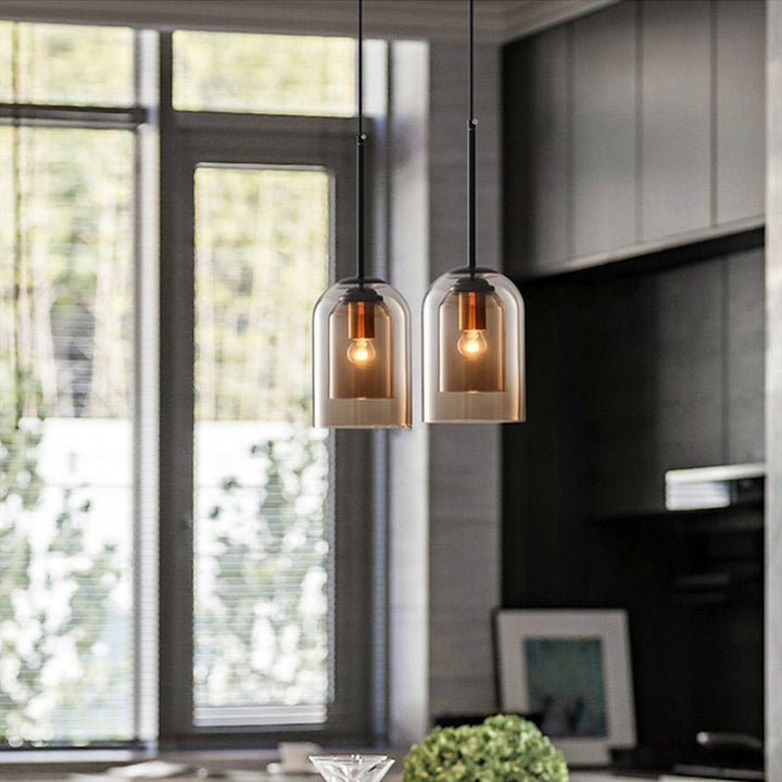 Twee amberkleurige hanglampen van dubbel glas boven een keukenblok, naast een groot raam 3