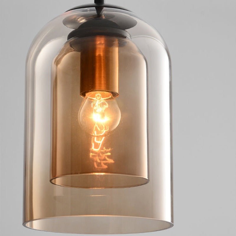 Close-up van de amberkleurige hanglamp met dubbel glas, koperkleurige fitting en een brandende lamp 9